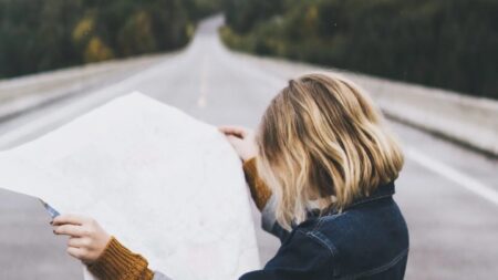 a woman looking at a map on a road